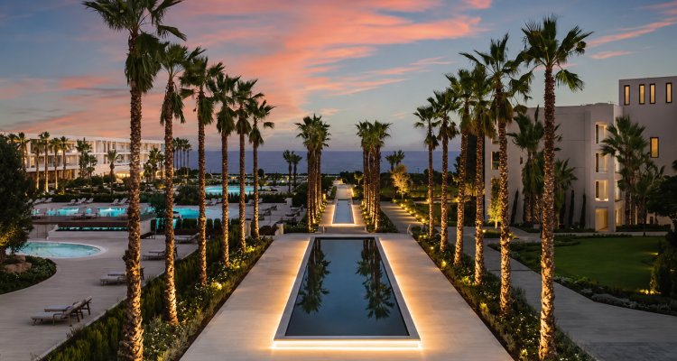 Resort contemporáneo frente al mar con paisajismo, palmeras, piscinas y arquitectura hotelera de lujo, vinculado a selección de talento especializado en arquitectura.